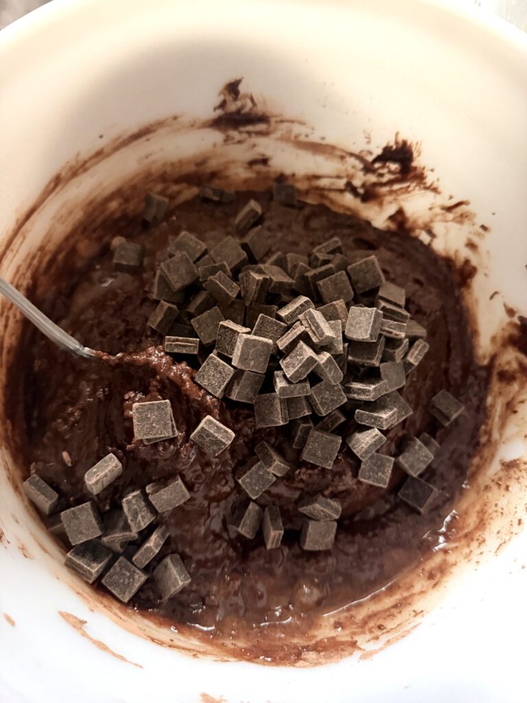 Dark chocolate chunks are added to brownie batter to increase the fudginess of the baked brownies.