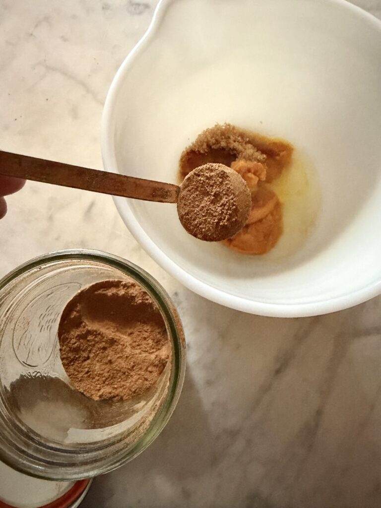 Egg white, pumpkin puree, brown sugar, and pumpkin pie spice are added to a bowl to make the pumpkin swirl in this fall brownie recipe.