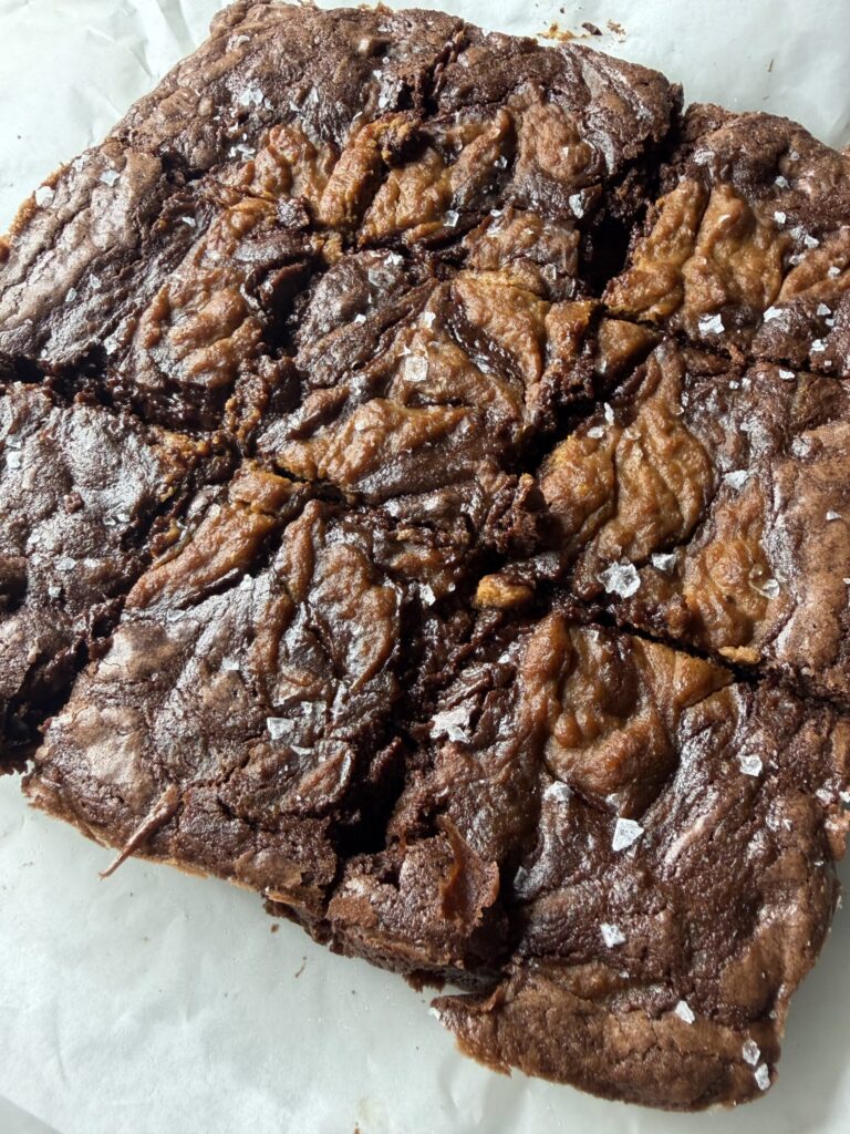 Delectable fudgy brownie squares with a sweet pumpkin pie swirl topped with flaky sea salt.