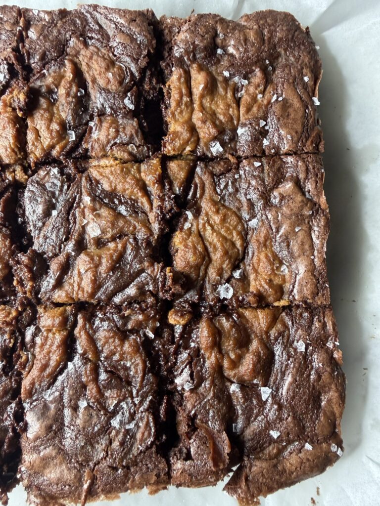A freshly baked pan of homemade pumpkin swirl brownies topped with flaky sea salt ready to serve.