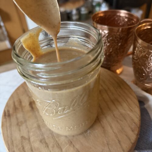 Pumpkin spice sauce in a mason jar on a wooden surface
