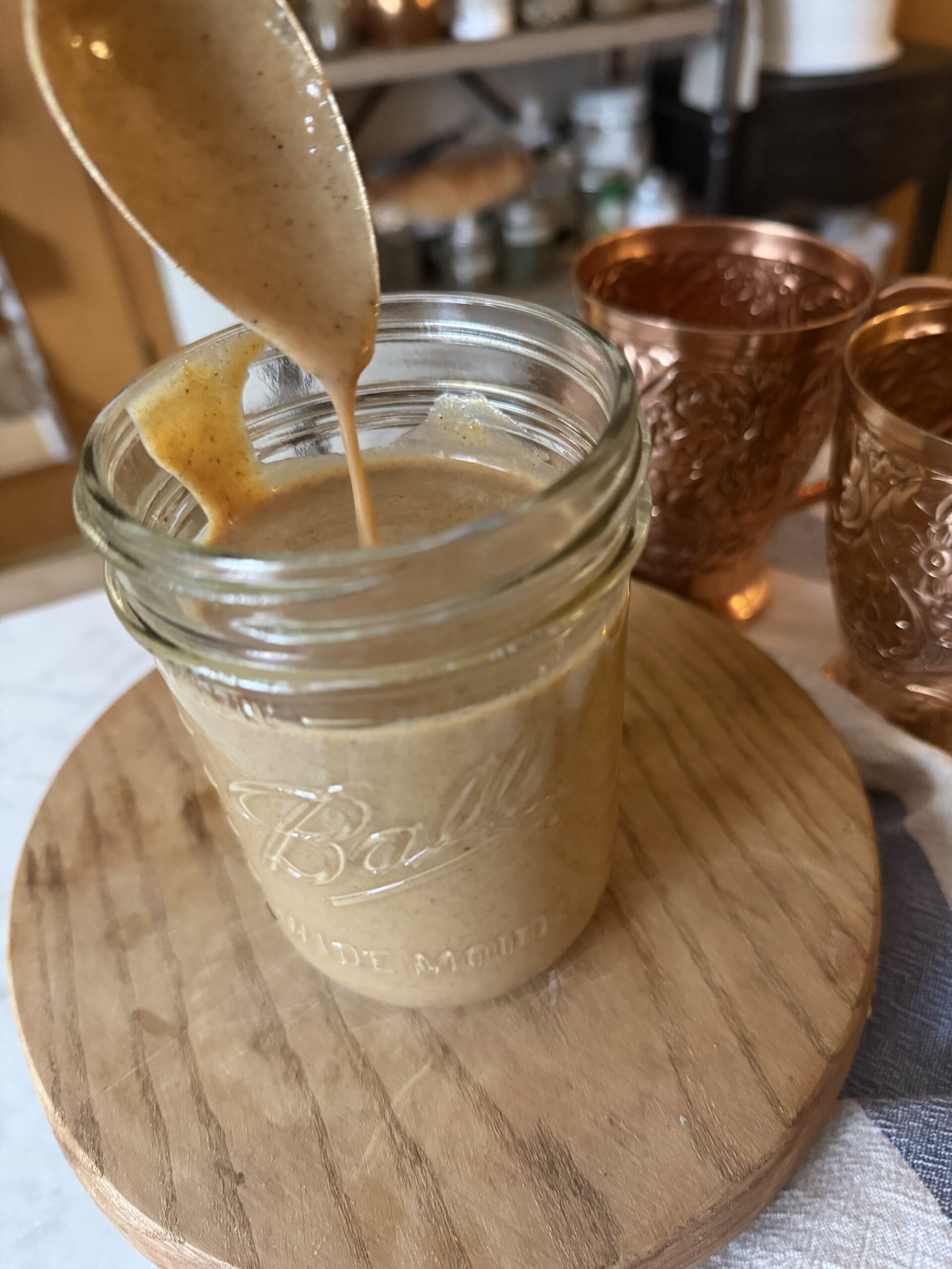 Pumpkin spice sauce in a mason jar on a wooden surface