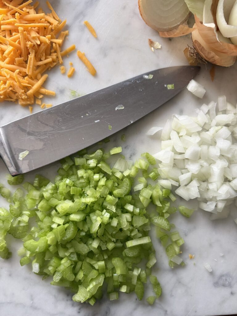 Chopped onions and celery on a marble surface