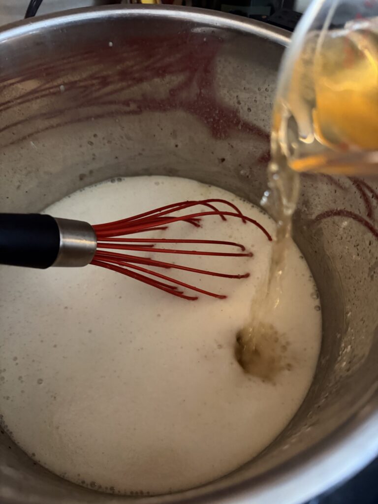 Modelo beer is added to the pot of ingredients while making creamy beer cheese soup