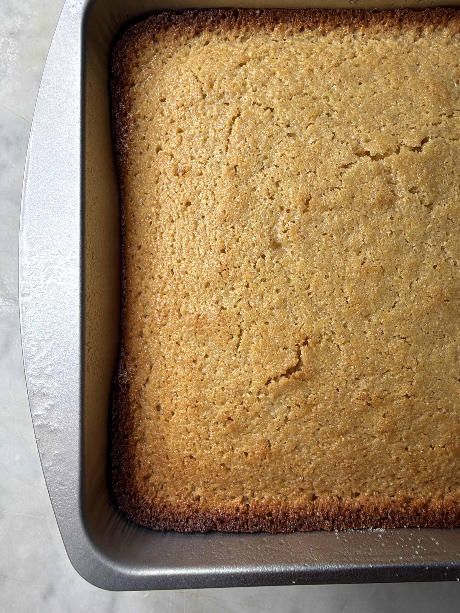 Golden freshly baked sourdough cornbread in a baking pan