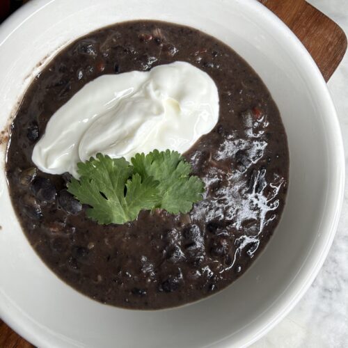 Cuban black bean soup garnished with greek yogurt and fresh cilantro