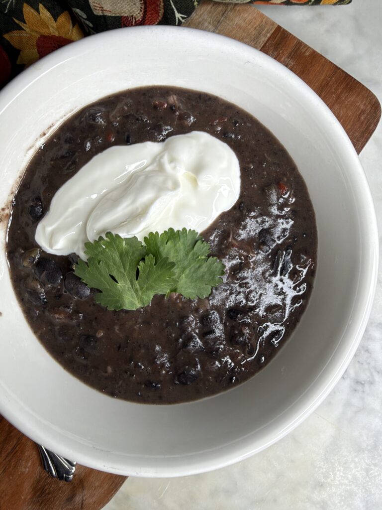Cuban black bean soup garnished with greek yogurt and fresh cilantro