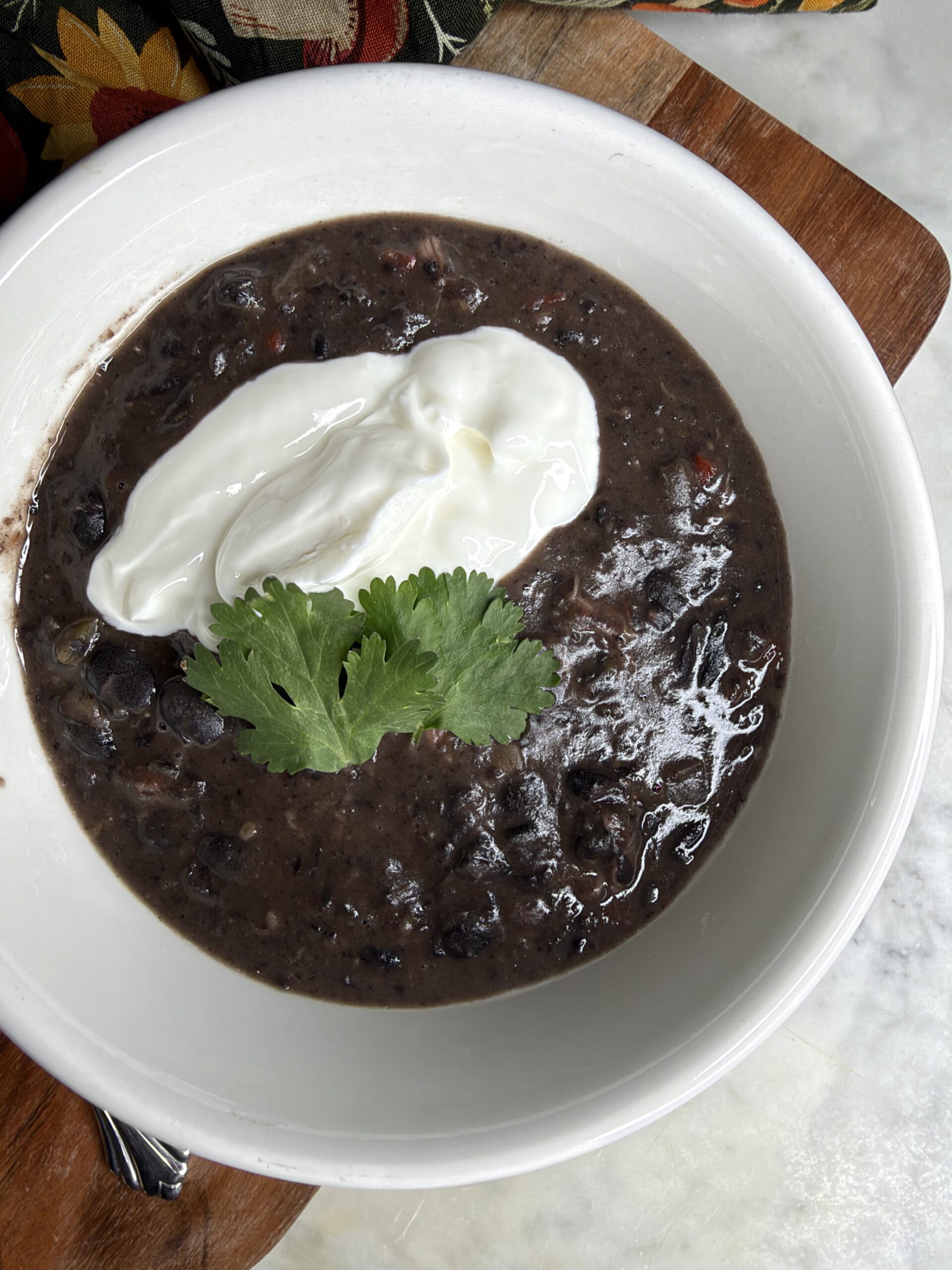 Cuban black bean soup garnished with greek yogurt and fresh cilantro
